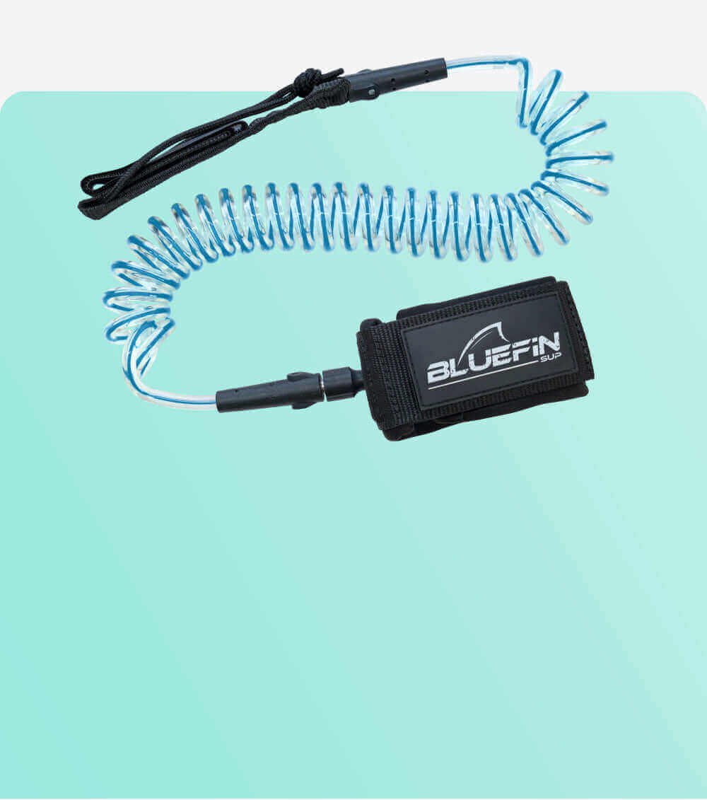 Coiled safety leash with black strap and blue cord, designed for paddleboarding use