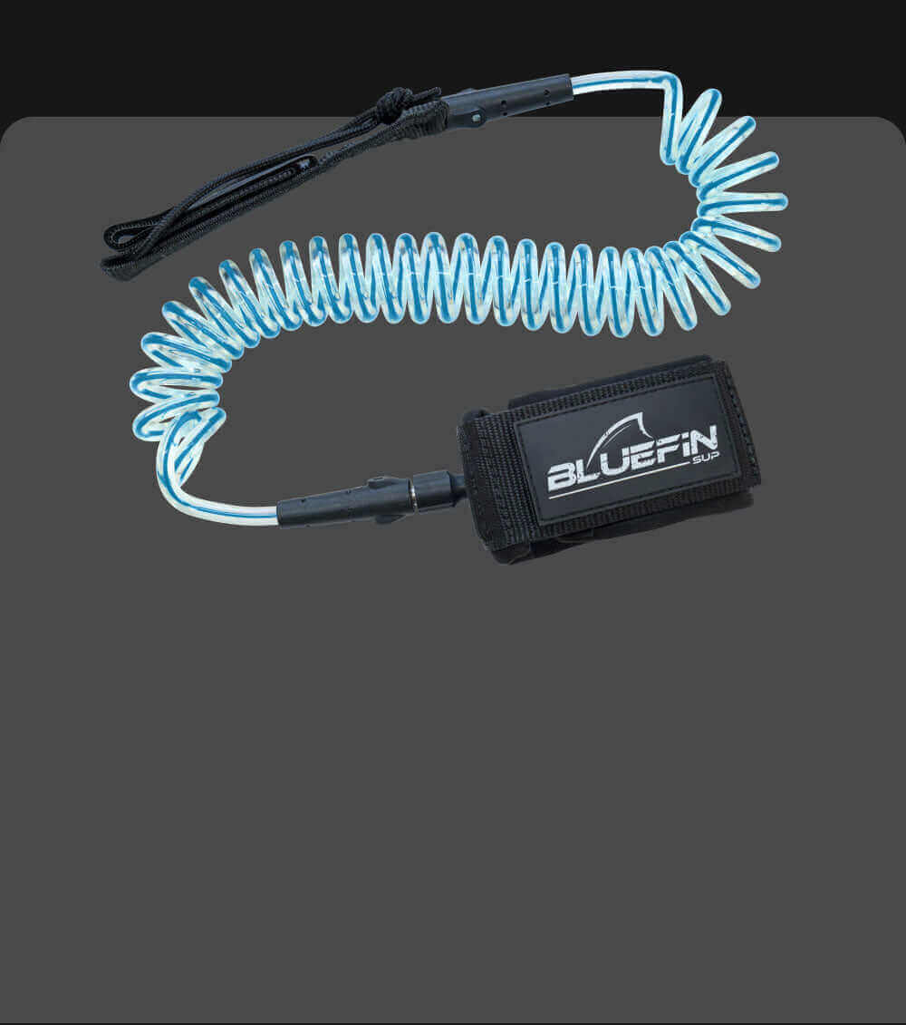 Coiled safety leash with black neoprene cuff and blue elastic cord for paddleboarding