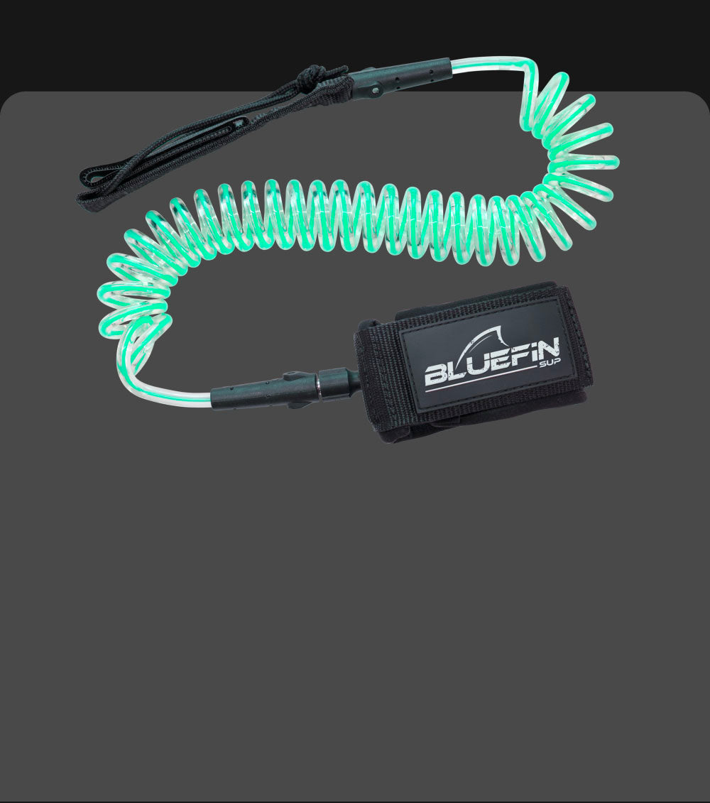 Coiled safety leash with a black neoprene cuff and green elastic cord for paddleboarding