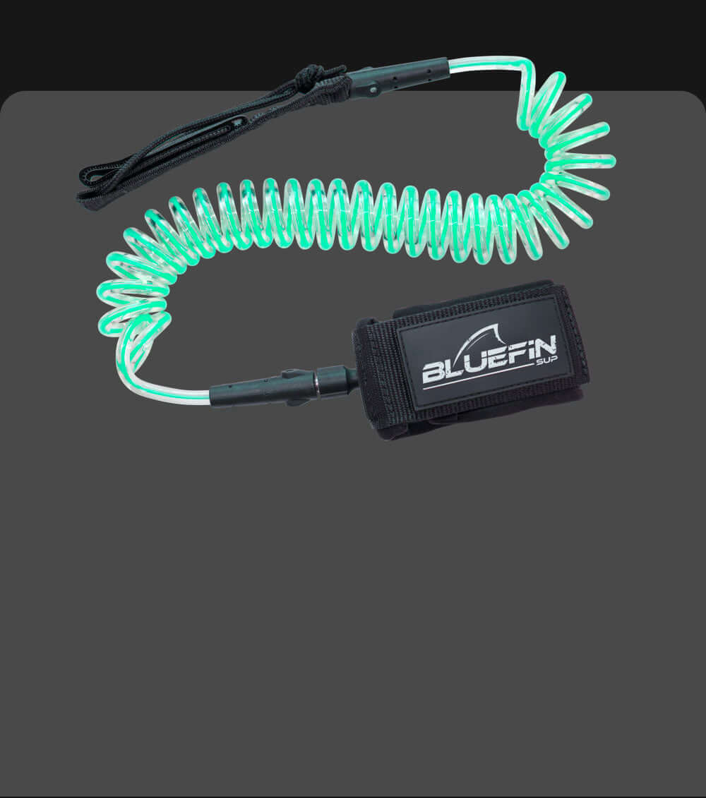 Coiled safety leash with a black neoprene cuff and green elastic cord for paddleboarding