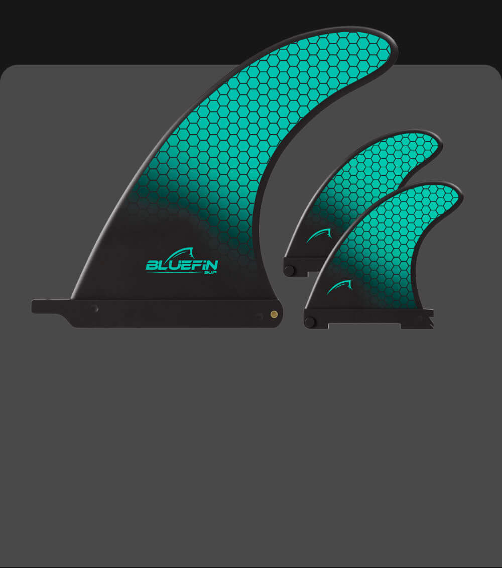 Three Bluefin SUP fins in varying sizes with a teal honeycomb pattern and logo on a dark background.