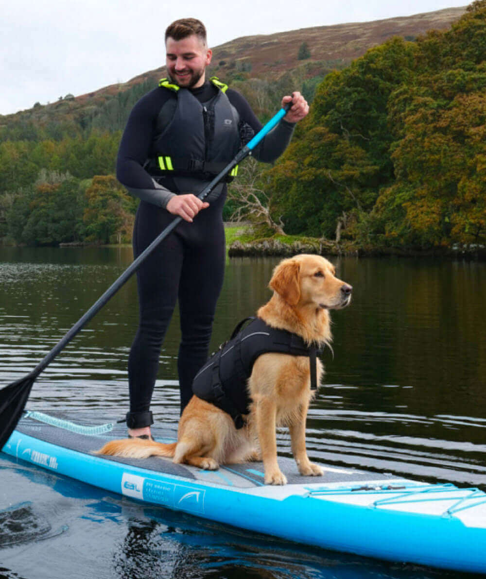 Man in wetsuit paddling on a blue inflatable paddleboard with a golden retriever sitting beside him
