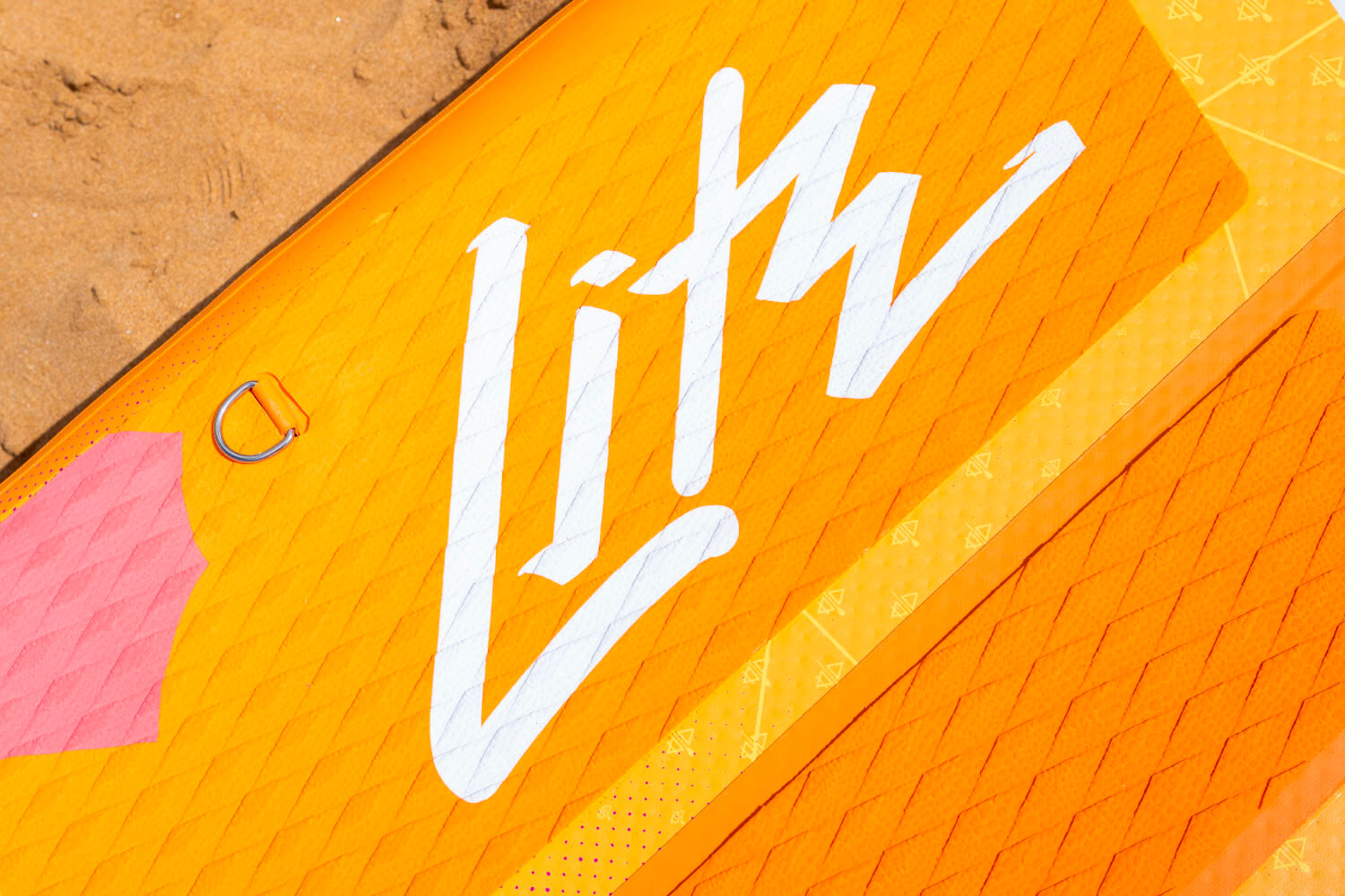 Orange inflatable paddleboard with white logo, textured surface, and a pink accent on the side