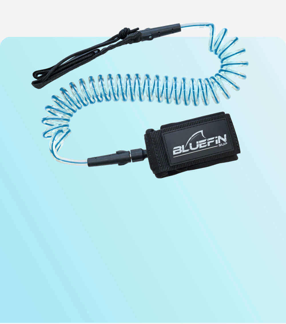 Coiled safety leash with black strap and blue cord, designed for paddleboarding use.
