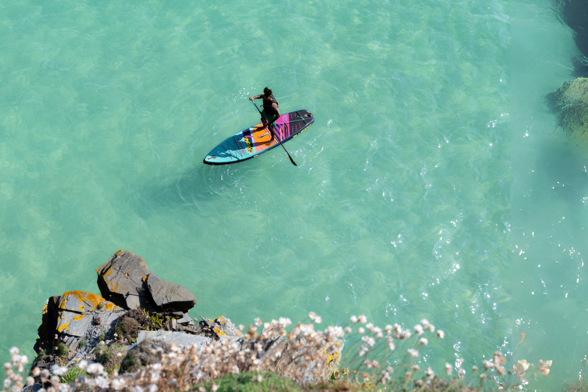 man paddleboarding on some clear ocean water
