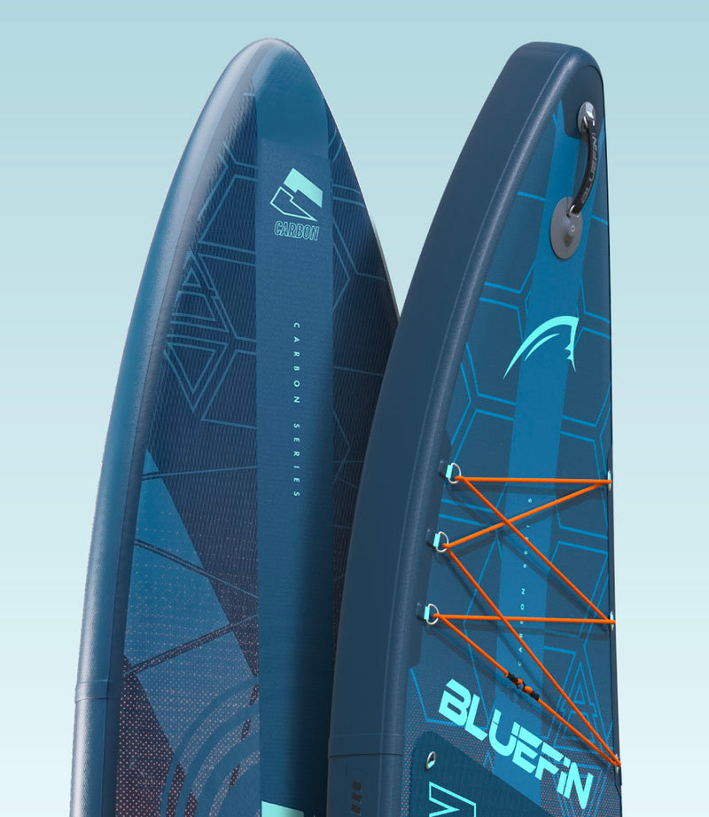 Two blue inflatable paddleboards with textured surfaces and orange bungee cords for gear storage
